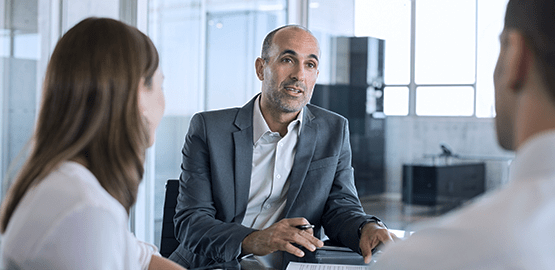 three people having a conversation in a meeting room