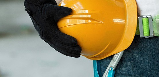 Construction worker carrying hardhat
