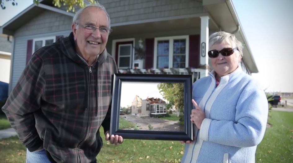 Des clients d’Economical tiennent une photo de leur maison ravagée par une tornade