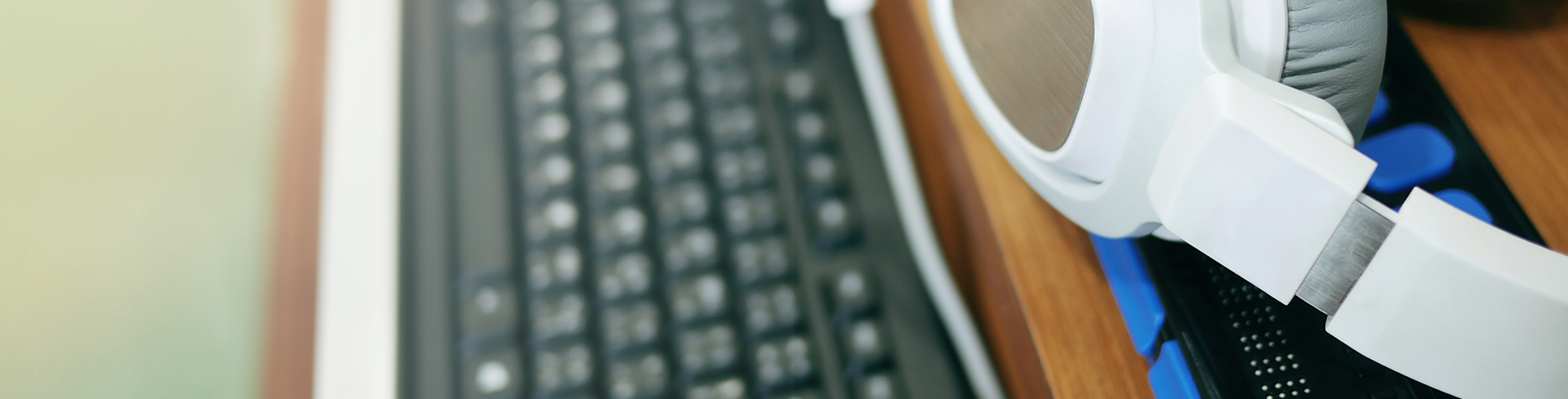 Gros plan sur un casque d'écoute blanc reposant sur un bureau à côté d'un clavier.