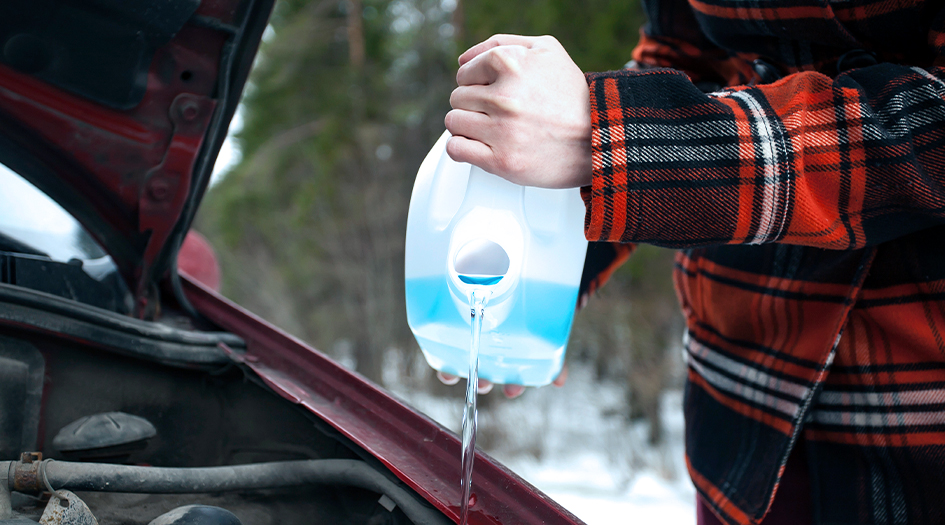 A man pours windshield washer fluid into his car, showing which windshield washer fluid you should use