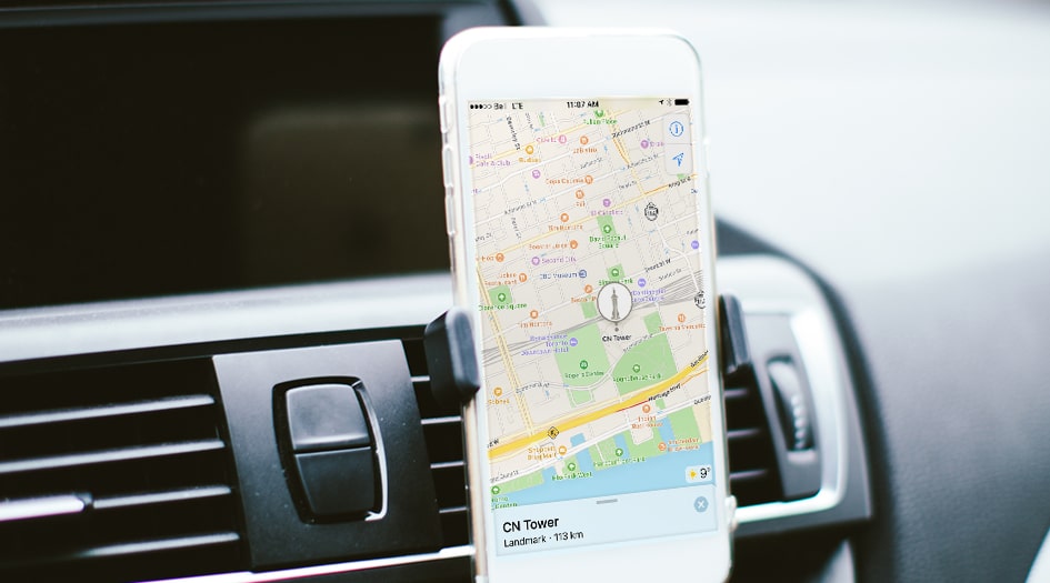 A close up of a smartphone on a car dashboard with a map shows you smartphone apps that help keep drivers on track