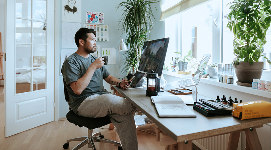 A man drinks coffee and looks at his computer as he considers 5 home insurance endorsements to add to his policy for extra coverage