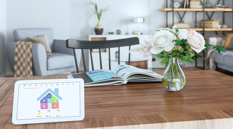 A tablet with a smart home monitoring system sits on the coffee table, protecting a home from risk