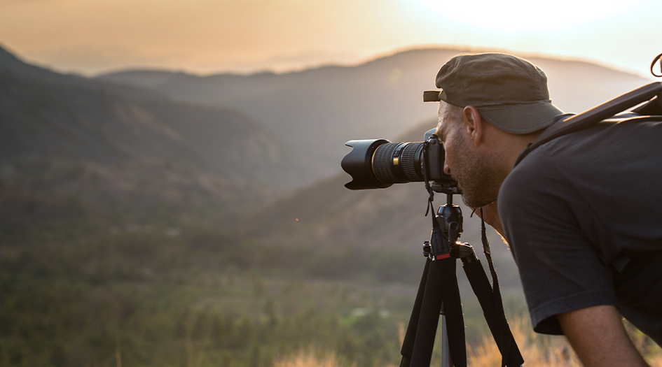 Here's how to insure your expensive camera gear, as shown by a man taking a photo outdoors with a professional camera