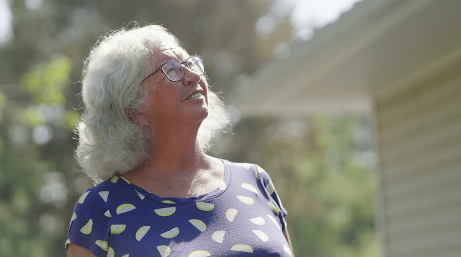 Vicki looks up at her home, admiring how fast how her insurance claim restored her property after Hurricane Fiona.