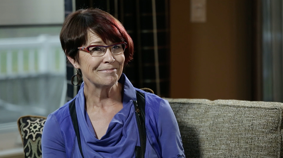 An Economical customer holds a picture of her damaged car in front of the fixed car