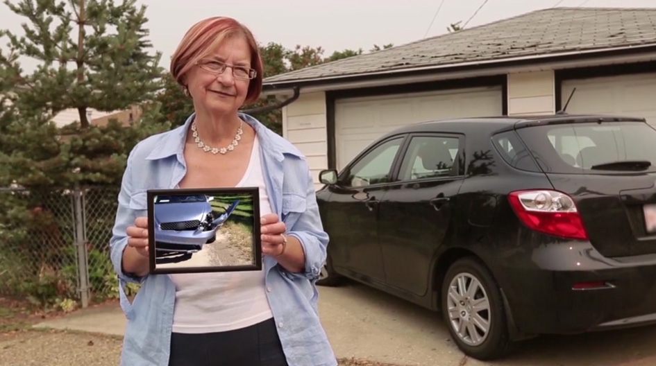An Economical customer holds a picture of her torn bumper