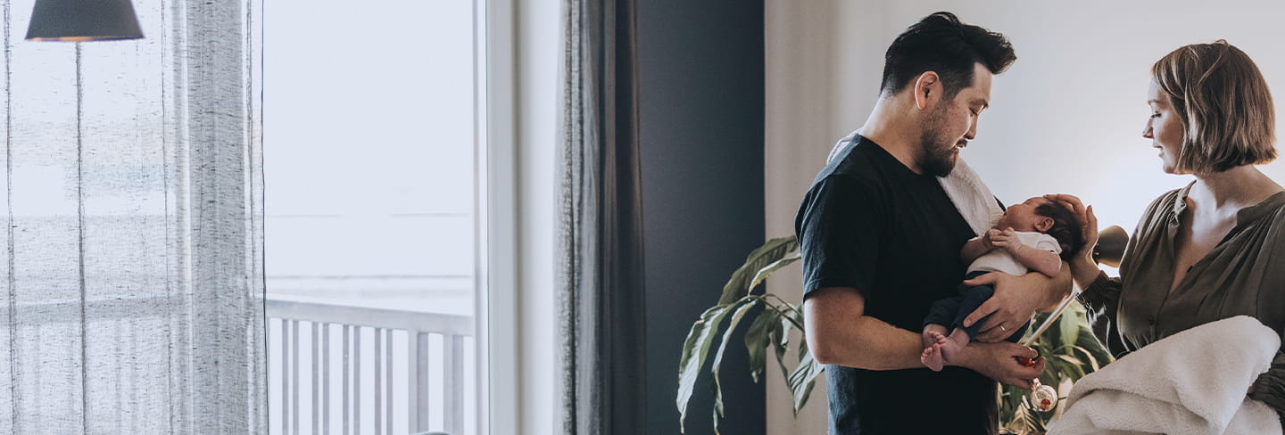 A young family standing in their living room