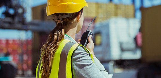 Une surveillante de la construction parle dans son radio