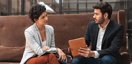 Two people sitting on a couch having a conversation