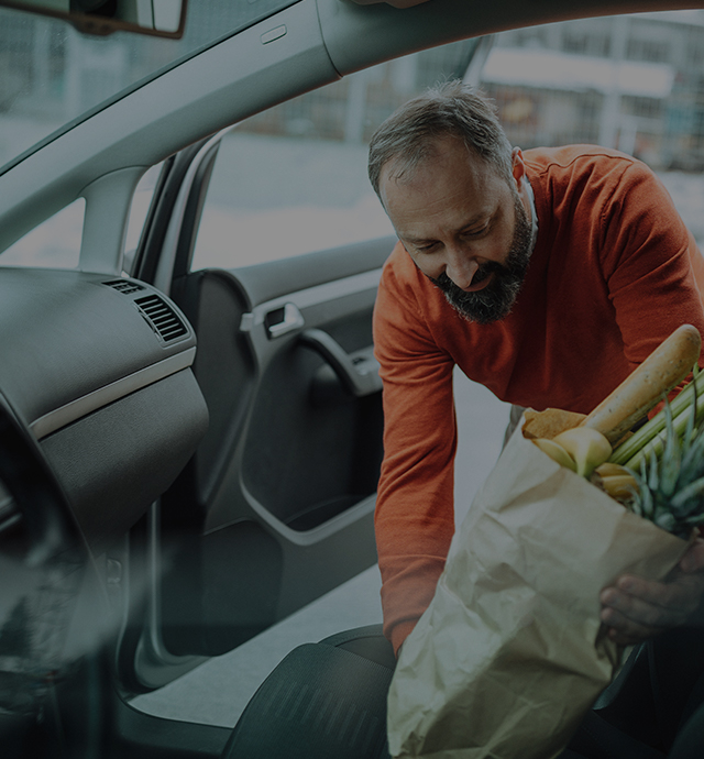 Person helping loads the groceries into the car