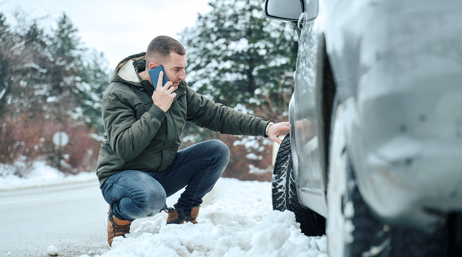 Un homme à côté de sa voiture au téléphone, illustrant quoi faire si vous avez un accident avec une voiture de location