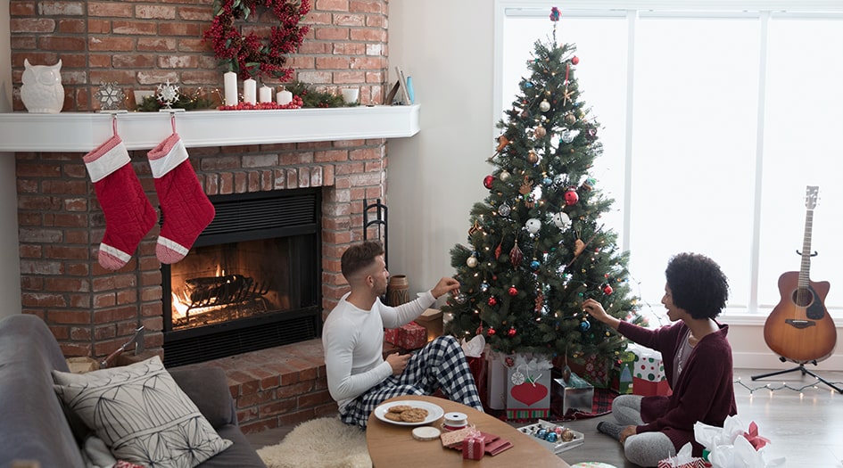 Un couple décore un sapin de Noël, illustrant comment votre assurance habitation vous protège pendant les fêtes.