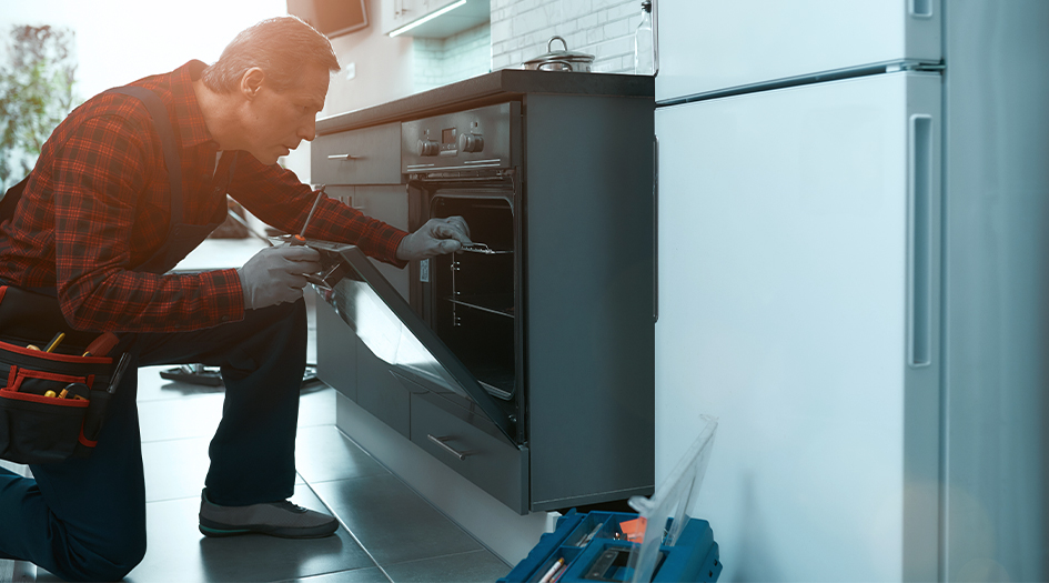 Un technicien observe l’intérieur d’un four, illustrant comment détecter une fuite de gaz naturel dans votre maison.