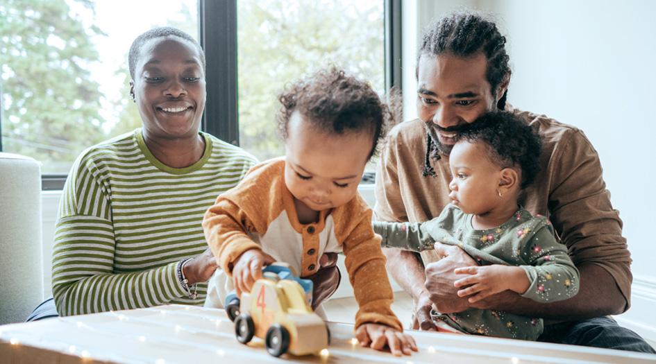 Nos besoins en matière d’assurance auto et habitation varient selon les étapes de la vie, comme pour ce couple qui joue avec ses deux jeunes enfants.