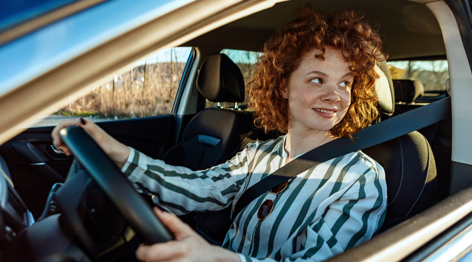 Questionnez-vous avant d’acheter une voiture d’occasion, comme cette femme assise dans une auto regardant vers l’arrière.