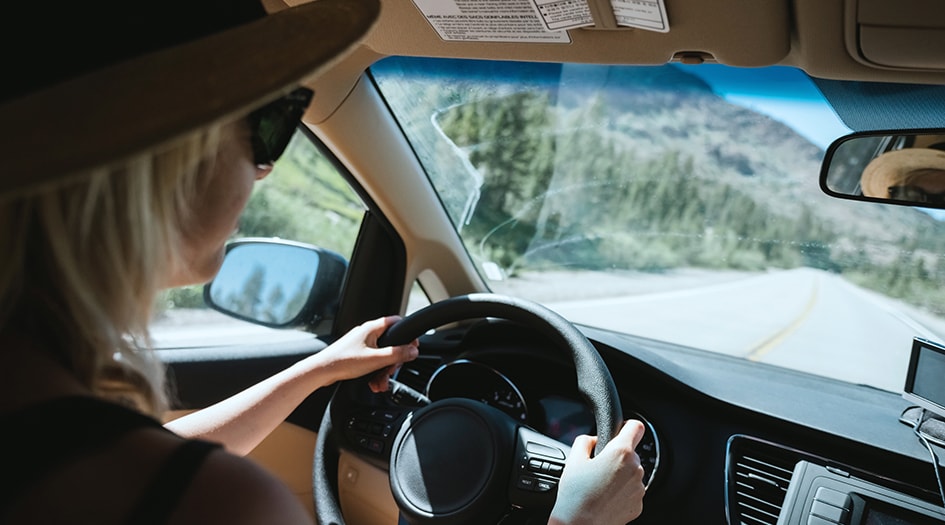 Nous devrions tous connaître les couvertures facultatives pour dommages matériels, comme en témoigne une femme portant un chapeau et des lunettes au volant.