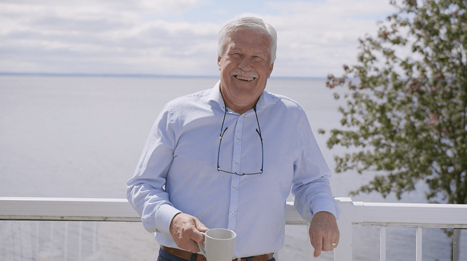 Garry profite de sa terrasse avec le lac en arrière-plan, montrant comment son indemnisation d'assurance a permis de remettre sa maison en état après un refoulement d'égout.