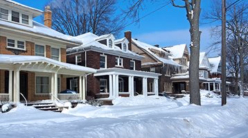 Here are 10 ways winter can damage your home, as shown by a row of houses covered in snow