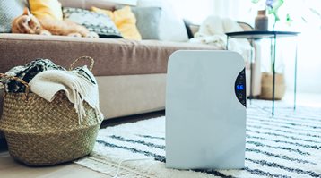 Here's whether home insurance covers mould, as shown by a dehumidifier in a living room