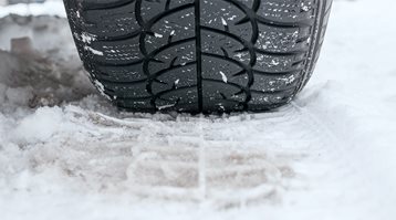 A close up of a tire on snow shows you why you need winter tires